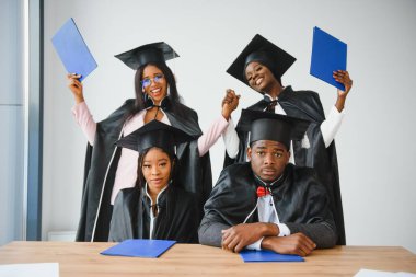 Eğitim, mezuniyet ve halk konsepti - Havan topu ve diplomalı bekarlık elbisesi giyen mutlu uluslararası lisansüstü öğrencileri grubu