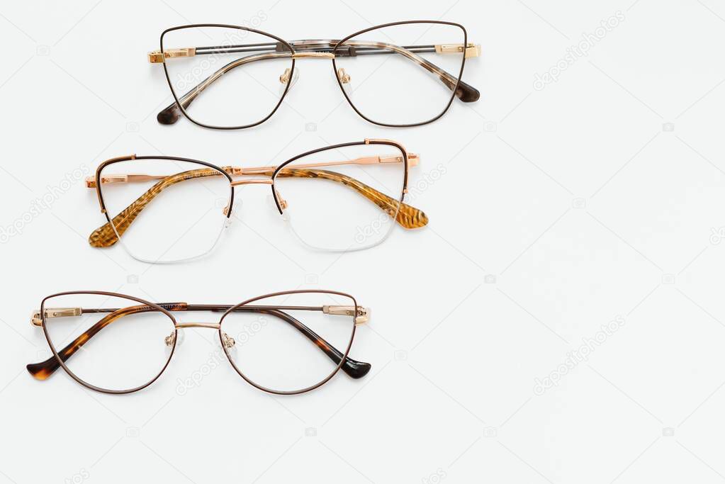 Stylish eyeglasses over background. Optical store, glasses selection, eye test, vision examination at optician, fashion accessories concept. Top view, flat lay