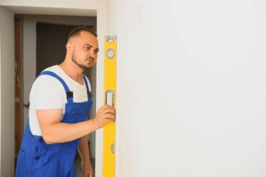 Yeni binada duvar uçağı yapan genç bir uzmanın portresi