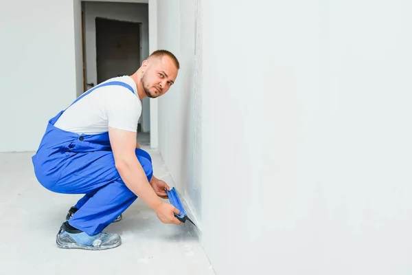 Retrato Trabajador Overol Sosteniendo Cuchillo Masilla Sus Manos Contra Fondo — Foto de Stock