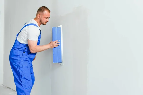 Retrato Trabajador Overol Sosteniendo Cuchillo Masilla Sus Manos Contra Fondo — Foto de Stock