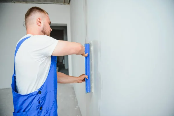 Retrato Trabajador Overol Sosteniendo Cuchillo Masilla Sus Manos Contra Fondo — Foto de Stock