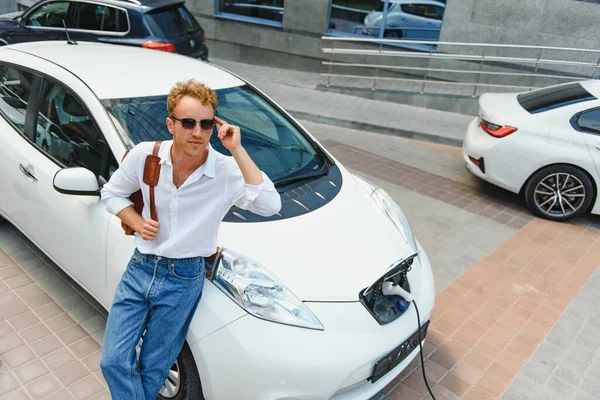 Mann Hält Stromladekabel Für Elektroauto Auf Outdoor Parkplatz Und Wird — Stockfoto