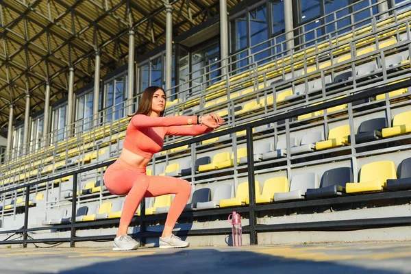 座ることフィットネス女性ワークアウト スタジアムで Ups スポーティな女の子の腹筋 屋外運動 — ストック写真