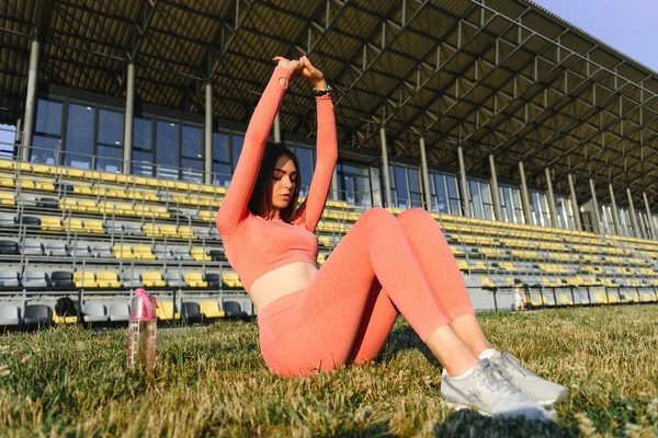 スポーツとウェルネス フィットネスの女の子がワークアウトをストレッチ 強い筋肉ボディトレーニングとファッションスポーティな女性 屋外スタジアムで女性のストレッチフィット — ストック写真