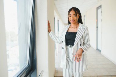 Ofiste resmi giyinmiş Afro-Amerikan iş kadını..