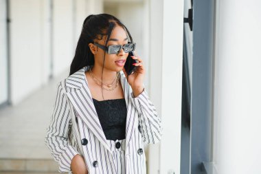 Ofisteki akıllı telefondan konuşan Afro-Amerikalı iş kadını, boşluğu kopyala