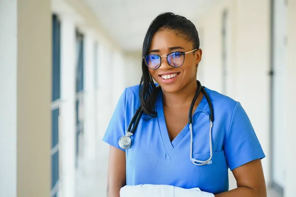 医療の概念 病院の背景に聴診器を持つ幸せなアフリカ系アメリカ人女性医師 — ストック写真