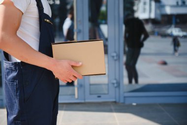 Paket kutusu olan bir postacı. Posta servisi.