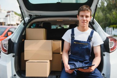 Kağıt kutusu tutarak gülümseyen teslimatçı