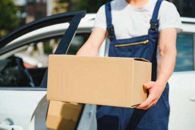 Paket kutusu olan bir postacı. Posta servisi.