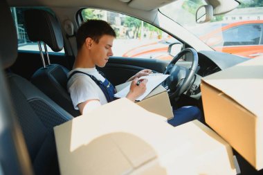 Paket kutusu olan bir postacı. Posta servisi.