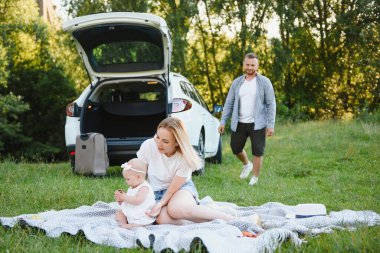 Ormandaki aile. İnsanlar arabanın yanında. Gün batımı arkaplanı.