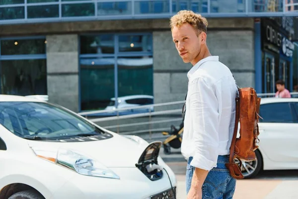 Mann Hält Stromladekabel Für Elektroauto Auf Outdoor Parkplatz Und Wird — Stockfoto