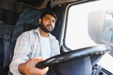 Genç Hintli bir adam ticari bir kamyon kullanıyor, yola odaklanıyor. Lojistik, ulaşım ve mesleği temsil ediyor.