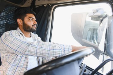 Yarı kamyon süren Hintli bir adam, yola odaklanmış. Lojistik, ulaşım ve profesyonel taşımacılık işi