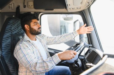 Kulübede el kol hareketi yapan Hintli erkek kamyon şoförü, nakliye ve lojistik sektöründe çalışıyor, uzun yol seyahati.