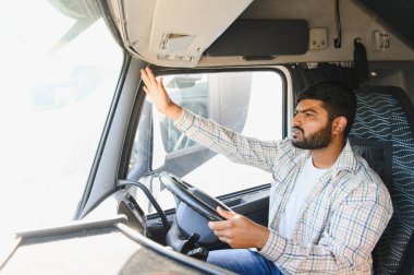 Kargo taşıyan genç bir adam, profesyonel şoför olarak çalışıyor, mal dağıtıyor ve lojistiği yönetiyor.