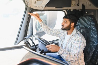 Hintli erkek kamyon şoförü uzun bir yolculukta lojistik ve taşımacılığı yönetiyor.