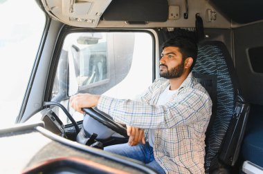 Ağır bir araç kullanan profesyonel Hintli kamyon şoförü öndeki yola odaklanıyor. Mal taşıma, lojistik konsept