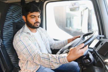 Ticari kamyon süren genç Hintli adam, malları taşıyor, şehirlerarası teslimat ya da lojistiğe odaklanıyor.