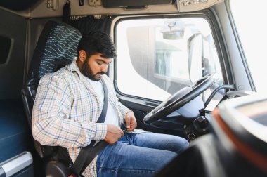 Kamyon şoförü emniyet kemerini takıyor ve uzun mesafeli taşımaya hazırlanıyor. Önce güvenlik kavramı