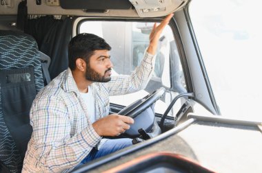 Hintli kamyon şoförü taksiyi sürüklüyor, uzun mesafe teslimat ve lojistik yolculuğa odaklanırken anlamlı jestler yapıyor.