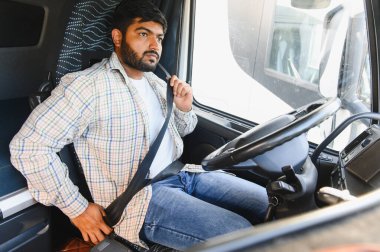 Hintli bir adam modern bir takside emniyet kemeri takıyor. Uzun bir yolculuğa çıkmadan önce güvenliği sağlıyor.