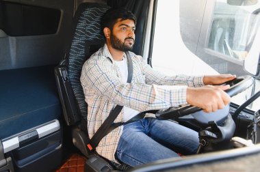 Hintli bir adam ağır bir araç kullanıyor, yolda ilerliyor, nakliye ve lojistik işleriyle uğraşıyor.