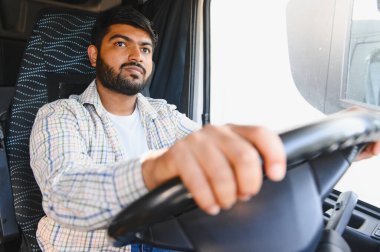 Hintli adam ağır bir araç kullanıyor, yola odaklanıyor, ulaşım, lojistik ve profesyonel sürüş