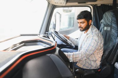Ulaşım, lojistik ve profesyonel kariyeri temsil eden büyük bir ticari kamyon süren genç Hintli adam.