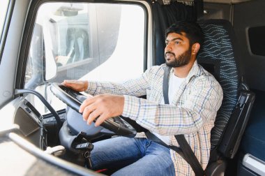 Genç adam ticari bir kamyon kullanıyor, malları taşıyor, güvenli ve verimli bir kargo teslimatı sağlıyor.