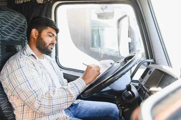 Taksideki Hintli kamyon şoförü evrakları dolduruyor ve panoya çek yazıyor. Lojistik, nakliye ve nakliye işleriyle uğraşıyor.