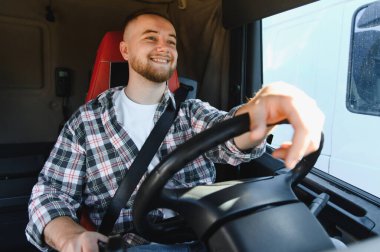 Büyük bir araç kullanan, nakliye şebekesinden mal taşıyan, gerekli işçiyi gösteren mutlu genç bir adam.