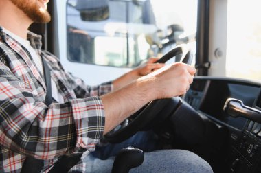 Endüstriyel kamyon kullanan bir adam, elleri direksiyonda. Ulaşım, lojistik ve profesyonel kargo teslimatı kavramı