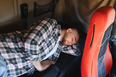 Uzun bir yolculuk boyunca ranzada uyuyan erkek kamyoncu dinleniyor ve yorgunluktan kurtuluyor.