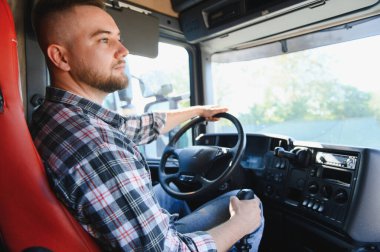 Yarı kamyon süren, yola odaklanan, lojistik, nakliye ve profesyonel teslimatı temsil eden genç bir adam.