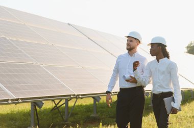 Çeşitli mühendisler, sürdürülebilir kalkınma ve temiz enerji projelerine odaklanarak, bir güneş enerjisi santralinde çalışmayı tartışıyor