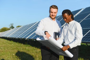İki farklı mühendis, büyük bir güneş enerjisi santralinde yenilenebilir enerji projesi planlıyorlar.