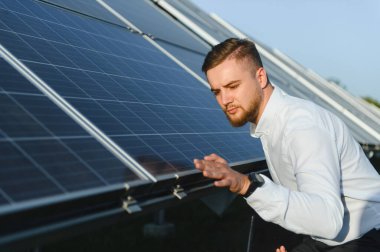 Güneş panelini inceleyen erkek mühendis, yenilenebilir enerji üretimi ve sürdürülebilir enerji çözümleri için optimal performans sağlıyor