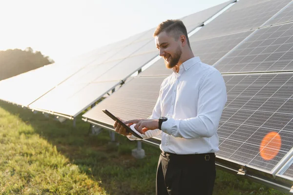 Yenilenebilir enerji ve sürdürülebilirliğe odaklanan dijital tabletle güneş enerjisi santralini izleyen mühendis