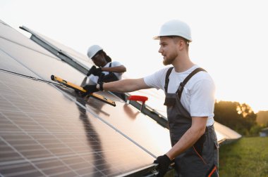 Yeni güneş panelleri kuran mühendisler, sürdürülebilir ve yeşil enerji üretimine hazırlık yapıyorlar.