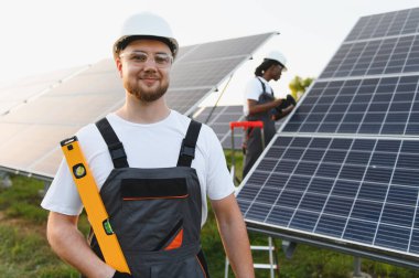 Güneş teknisyenleri, yenilenebilir enerji ve sürdürülebilirliği destekleyen yeni bir güneş paneli sistemi kurup bağlıyorlar.