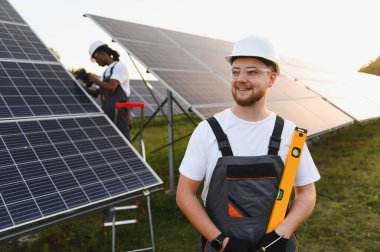Mutlu mühendis fotovoltaik güneş panelleri kuruyor, yeşil enerjiye ve sürdürülebilir enerjiye katkıda bulunuyor