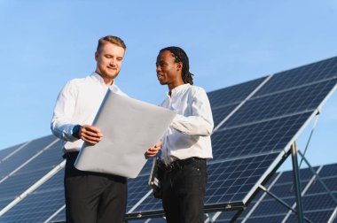 Bir enerji santralinde güneş enerjisi projesinin planını tartışan mühendisler, yenilenebilir enerji ve temiz enerjiye odaklanıyorlar