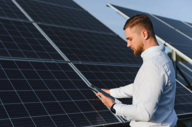 Bir enerji santralinde güneş enerjisi üretimini izleyen adam, verimli bir işletme ve sürdürülebilirlik sağlıyor