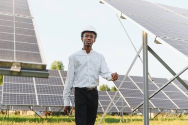 Güneş panellerini kontrol eden, yenilenebilir enerji ve sürdürülebilir enerji üretimine odaklanan, sert başlıklı Afrikalı mühendis.