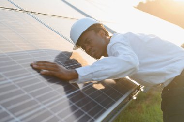 Mühendis günbatımında güneş panelini inceleyerek verimli yenilenebilir enerji üretimi ve sürdürülebilir temiz enerji üretimini sağlar.