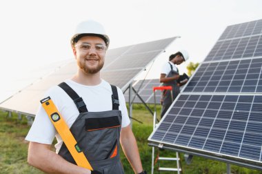 Mühendisler bir alana fotovoltaik güneş panelleri kurarak temiz ve sürdürülebilir elektrik enerjisi sağlıyorlar