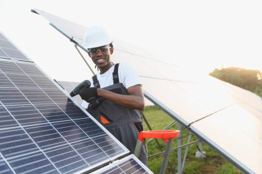 Afrikalı Amerikalı teknisyen fotovoltaik paneller kuruyor, yeşil enerji üretimine ve sürdürülebilir enerji üretimine katkıda bulunuyor